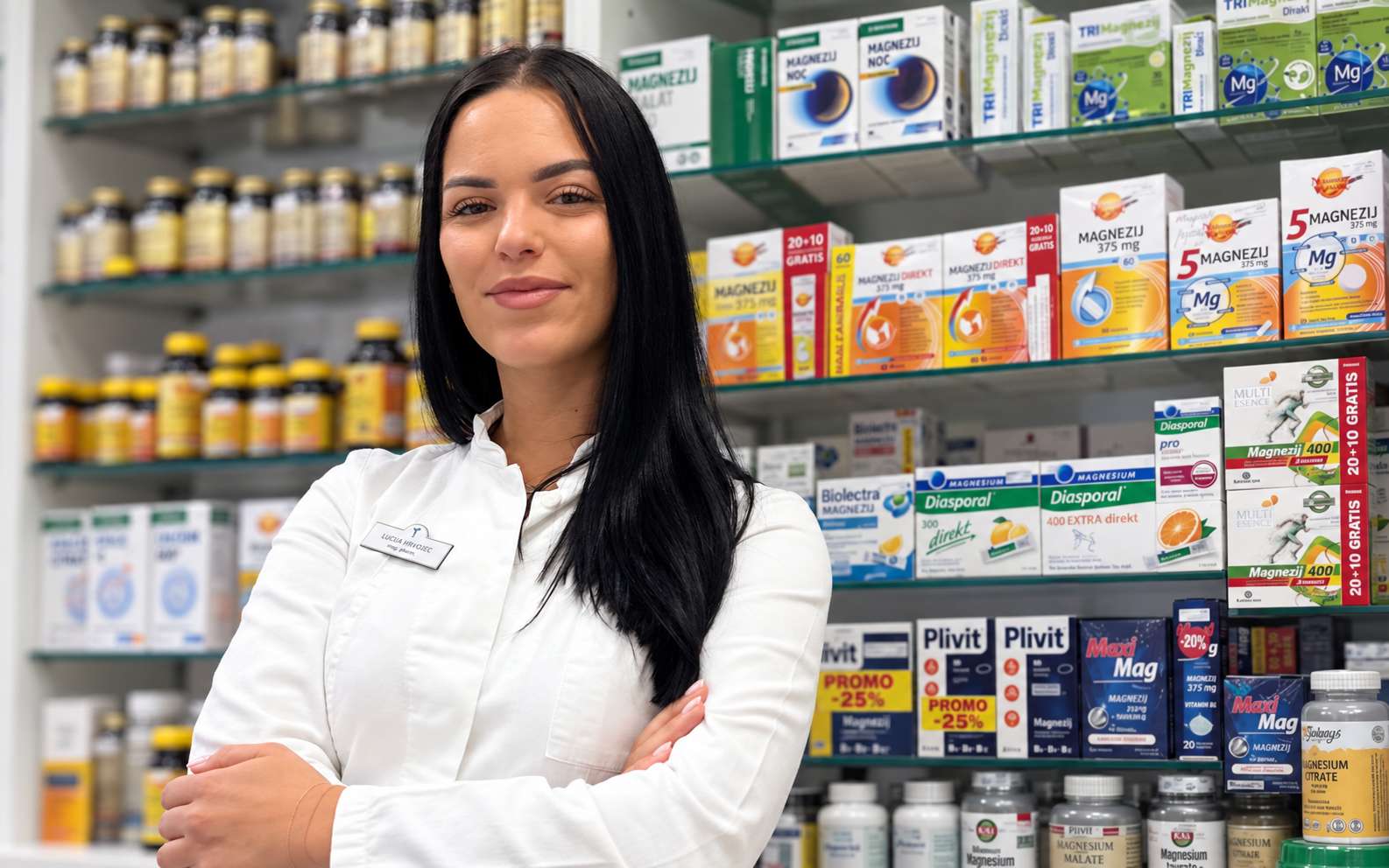 Farmaceutkinja u ljekarni ispred police s pripravcima magnezija